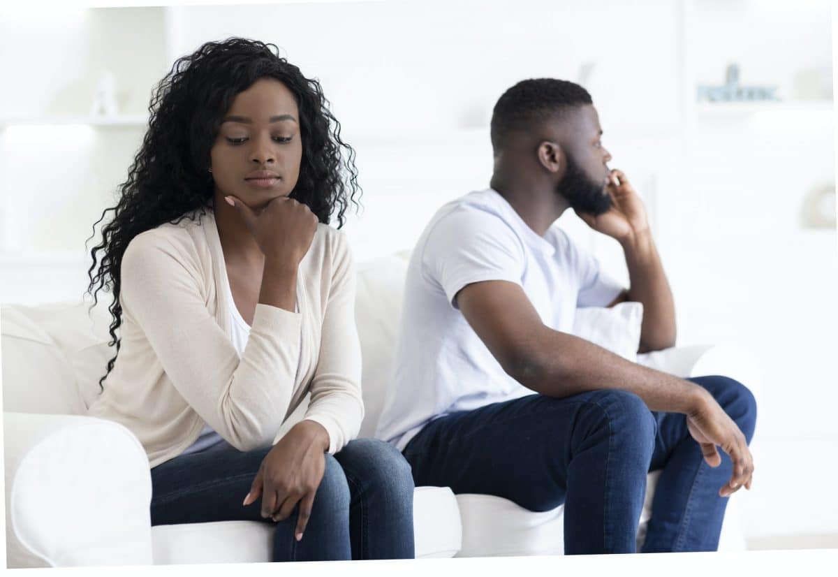 Couple Sitting On Different Sides Of Couch After Quarrel