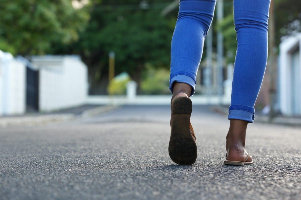 Female legs walking on the road