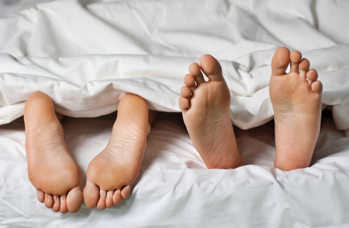 Sex addition, couples feet outside the comforter